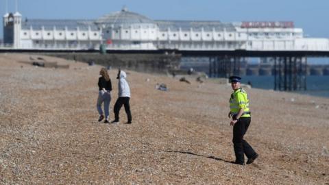 A police officer patrols Brighton beach on April 04, 2020 in Brighton, England.