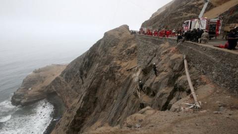 Rescue workers work at the scene after a bus crashed with a truck and careened off a cliff along a sharply curving highway north of Lima, Peru, January 3, 2018. REUTER