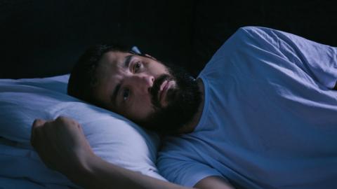 Man lying awake in bed
