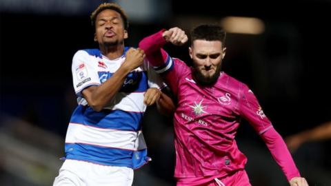 Chris Willock and Matt Grimes tussle for the ball