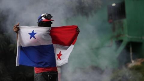 Hooded demonstrators participate in a new day of protests in the midst of the strike called by unions due to the high cost of fuel and food, at the National University of Panama, in Panama City, Panama, 11 July 2022.