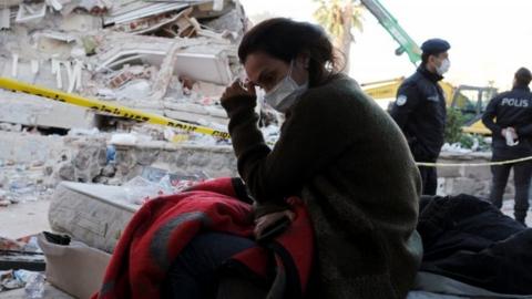 A woman reacts next to debris during rescue operations after an earthquake struck the Aegean Sea, in the coastal province of Izmir, Turkey, 31 October 2020.