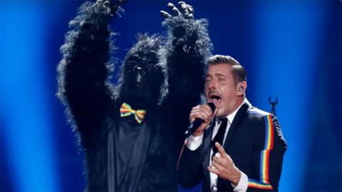 A person in a costume and a man singing