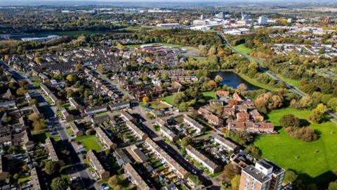 An aerial view of Harlow. Terraced housing, a residential apartment block and the tower blocks in the town centre are visible