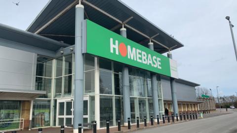 A former Homebase store with a grey frontage and road in front of it