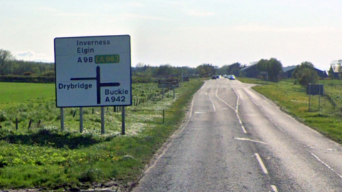 A road sign on the A98 showing Inverness and Elgin ahead, Drybridge to the left and Buckie to the right