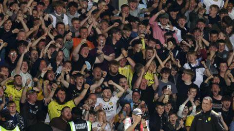 Burton Albion fans celebrate behind manager Gary Bowyer