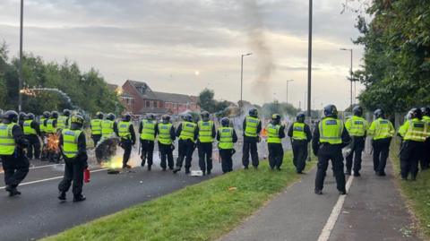 A line of police and a firework