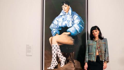 Lily Allen standing in front of her portrait at the National Portrait Gallery Copyright