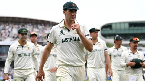A glum-looking Australia captain Pat Cummins leads his players off the field at the conclusion of the World Test Championship final