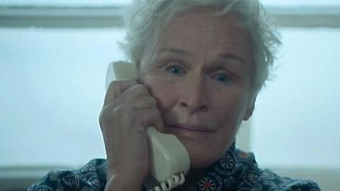 Actress Glenn Close speaks into a telephone in a scene from The Wife