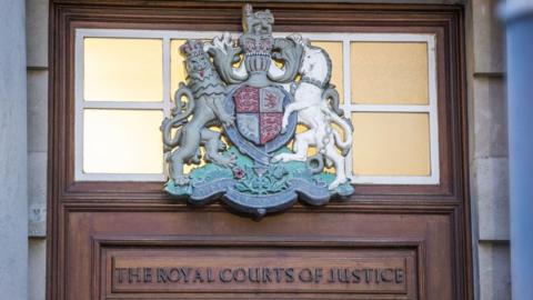 The Royal Courts of Justice sign and logo