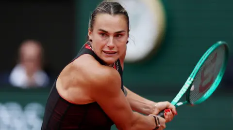 Aryna Sabalenka leans into a backhand