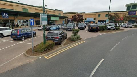 Westgate Shopping Park, featuring a number of large stores with a car park in front next to an access road.