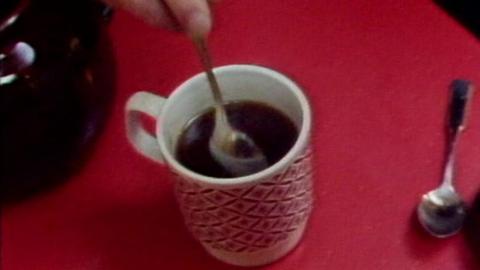 Red cup of tea with a tea spoon in it 