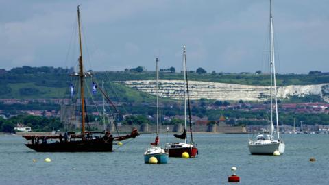 MONDAY - Boats moored off Portchester with a white cliff behind