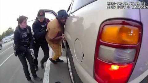 Two officers are helping a man.