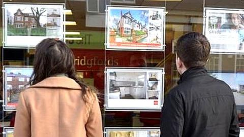 People looking in estate agents window