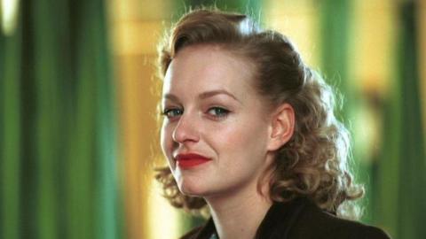 Christine Tremarco has wavy blonde hair and wears bright red lipstick while dressed in 1940s style clothes in the 2002 movie Night Flight.