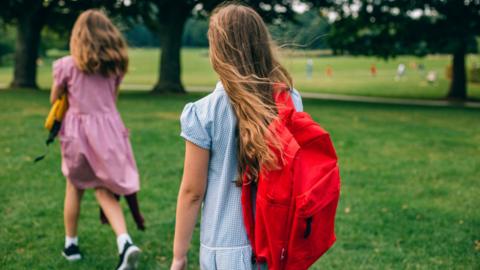 Two girls walking in a park