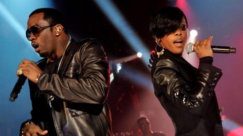 Diddy and Dawn Richard singing into microphones together on stage with their backs to each other, at The Old Fruit Market in Glasgow in 2010