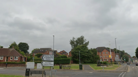 Junction between two roads, with traffic lights in the background
