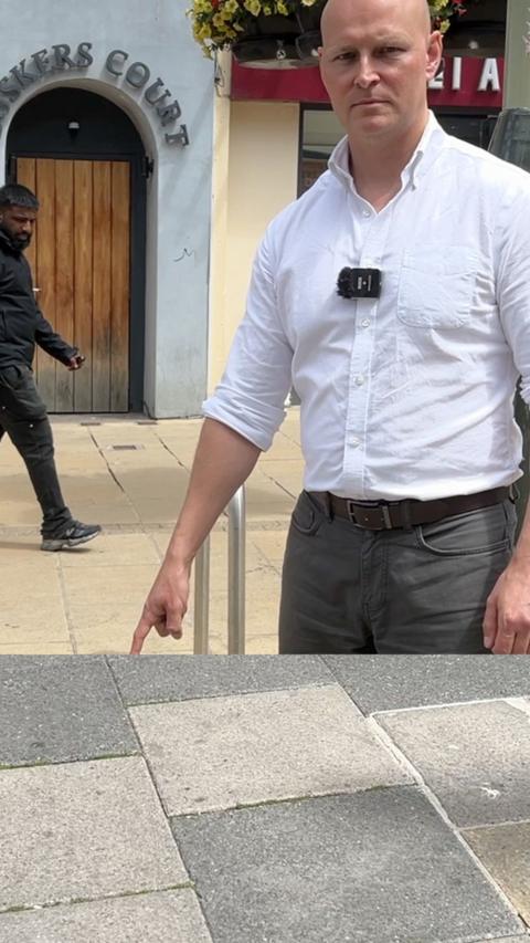 Man pointing to the tarmac looking stern.