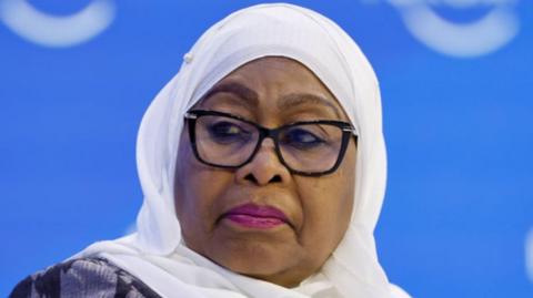 President Samia Suhulu Hassan wears black-rimmed glasses and pink lipstick at a panel discussion