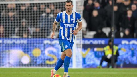 Lewis Dunk dribbling the ball in a Brighton kit