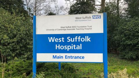 The blue and white West Suffolk Hospital entrance sign in Bury St Edmunds.