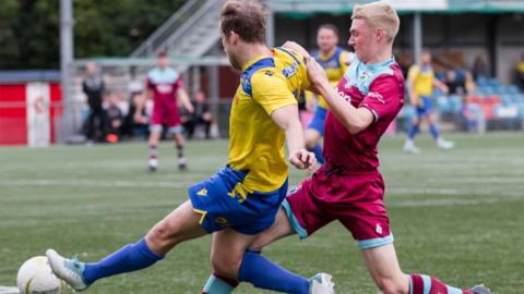Colwyn Bay's Joel Giblin battles for the ball against Barry Town