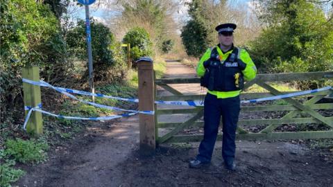 Police officer in front of police cordon at Marston Marsh