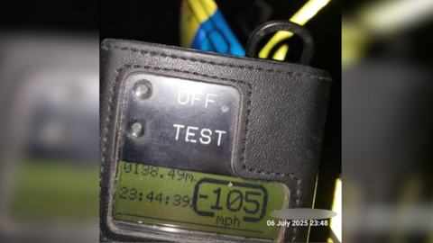 A police speeding device has a digital display that shows the time, which is 23:44:39, and a speed of 105mph.