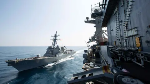 The Nimitz-class aircraft carrier USS Abraham Lincoln (CVN 72) sails alongside the Arleigh Burke-class guided-missile destroyer USS Spruance (DDG 111) during a fueling-at-sea.