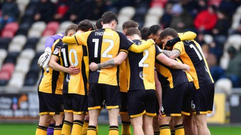 Newport County players in a group huddle