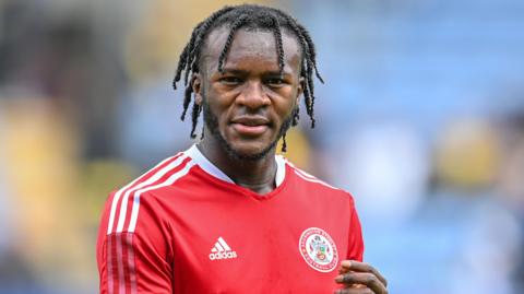 Rosaire Longelo standing on the pitch during an Accrington match