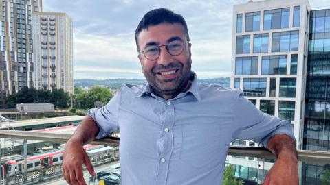 Llun o Hammad Hassan Rind yng Nghaerdydd - un o ymgeiswyr cystadleuaeth Dysgwr y Flwyddyn 2025