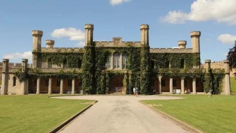 Lincoln Crown Court a two-storey  Victorian Gothic building with stone pillars, crenellated roof and six towers with ivy growing up its walls