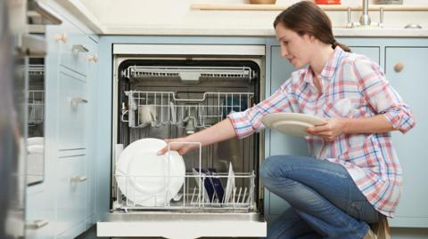 Woman stacking dishwasher