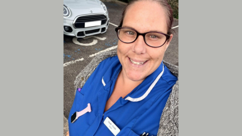Sarah Jayne Crook, a woman in her 30s, is wearing a nurse's uniform. She is smiling and has dark hair. 