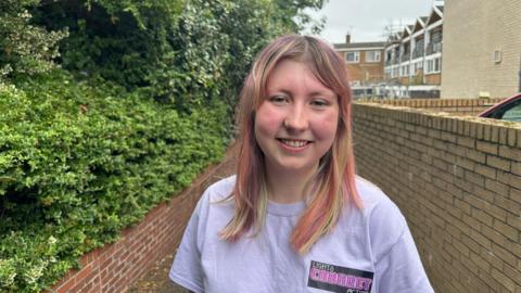 Gabrielle Hammond in a light T-shirt, smiling at the camera