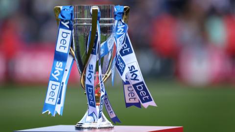 A general view of the League Two trophy on a stand with blue and white ribbons attached
