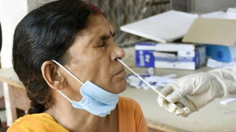 A health worker collect swab sample from a woman for a Covid-19 test at Gardiner Hospital on July 13, 2022 in Patna, India.