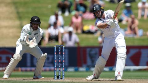 England's Gus Atkinson hits out, watched by New Zealand wicketkeeper Tom Blundell, in 2024