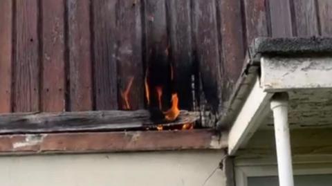 Burning cladding on the outside of a house.