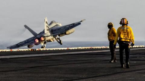 A fighter jet takes off from a US aircraft carrier in the Gulf