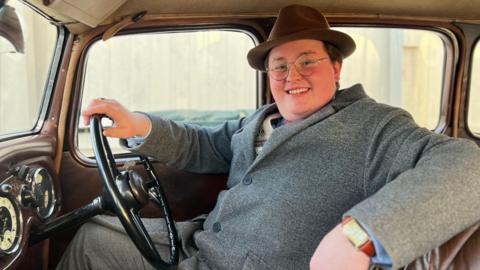 Callum smiling in his car