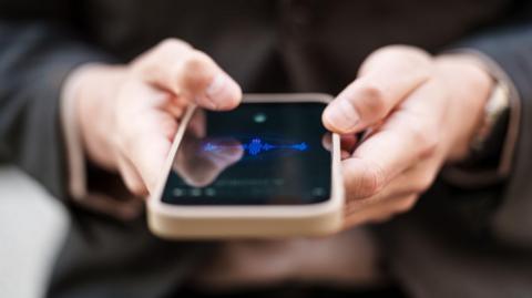 Close-up view of adult hands holding a smartphone displaying a digital interface. The image highlights mobile technology, screen interaction, and modern digital communication without revealing personal identity.