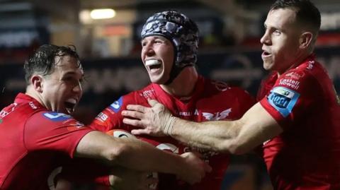 Tom Rogers celebrates with Ioan Lloyd (L) and Gareth Davies (R)