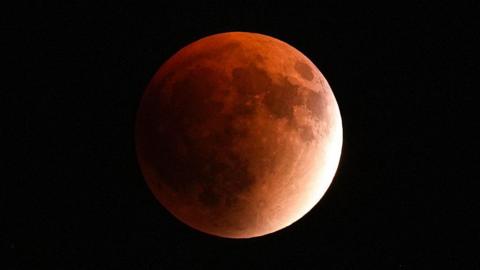 : A red full moon, also known as a blood moon, is seen during a lunar eclipse in Sinop, Turkye, on September 7, 2025